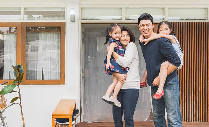 a family of 4 in front of a house