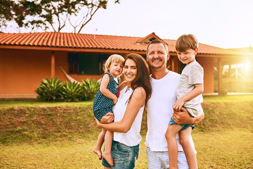 a family of 4 in front of their new home